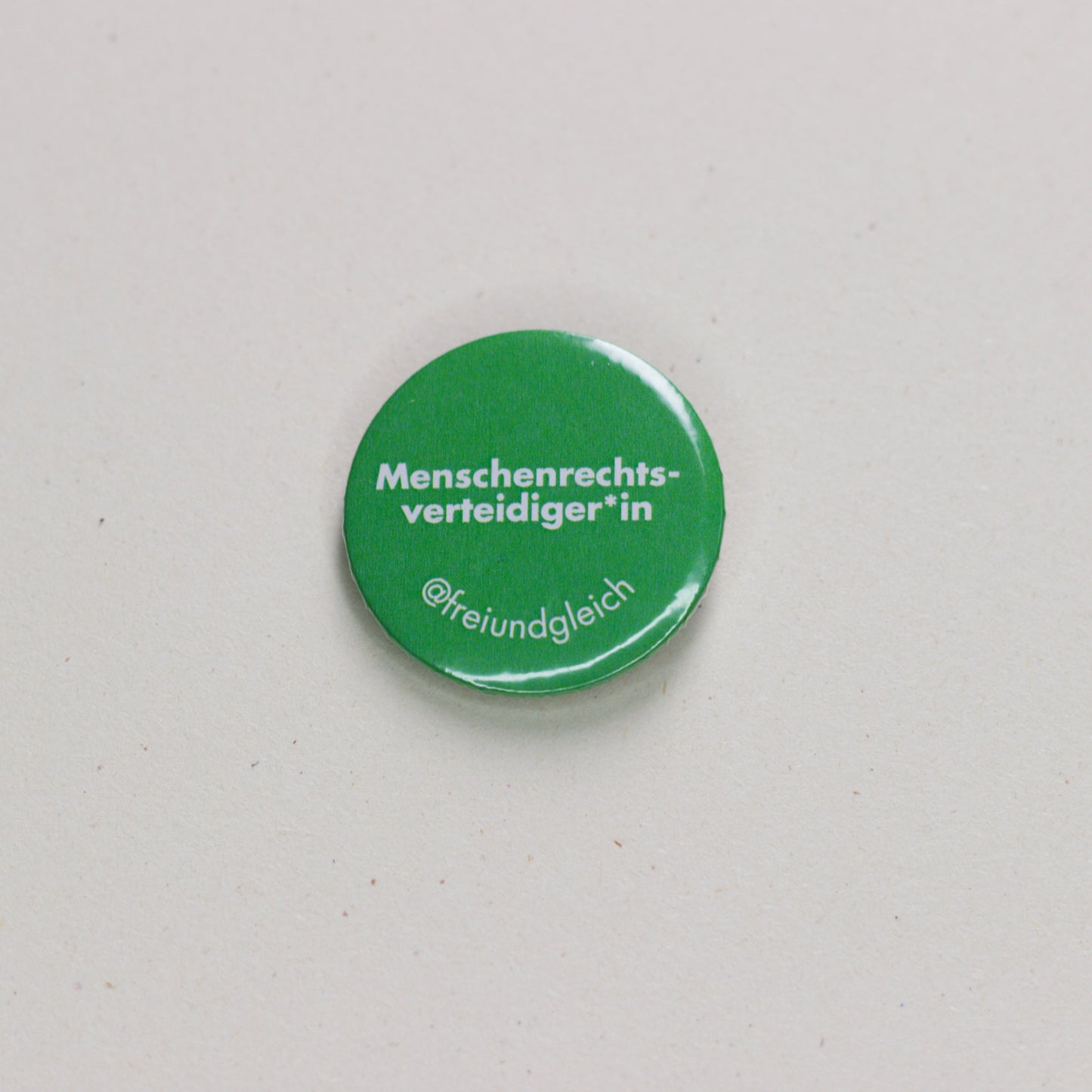 Button "Menschenrechts-Verteidiger:in" mit Anstecknadel aus Metall